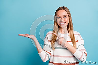 Photo of cheerful positive pretty sweet woman pointing at empty space on her palm smile toothy isolated pastel blue Stock Photo