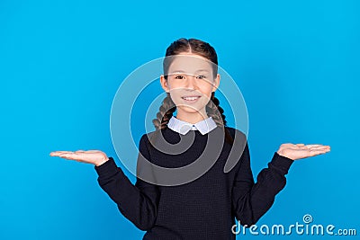 Photo of cheerful smiling girl advertise product hold hands in balance alternative offer on blue color Stock Photo