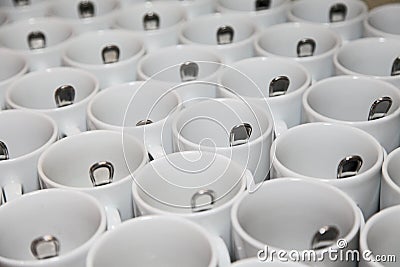 Photo closely standing diagonal rows together 29 white porcelain mugs with stainless steel spoons Stock Photo