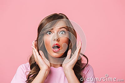 Photo closeup of scared woman with long curly hair in basic t-shirt bulging eyes and raising hands in fear or panic, isolated Stock Photo