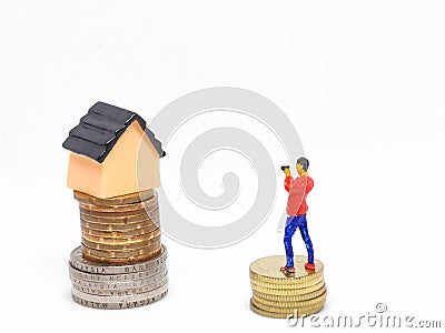 Photo of coins with miniature house and human isolated on white background. Stock Photo