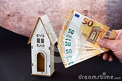 photo concept of a hand that puts money into the purchase or maintenance of the house Stock Photo