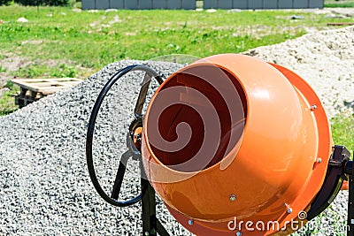 Photo concrete mixer installed on the construction site next to a pile of sand and gravel. Stock Photo