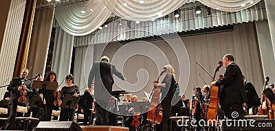 Photo conductor and musicians. Musical concert in the Philharmonic. Violin player. Music concert background Editorial Stock Photo