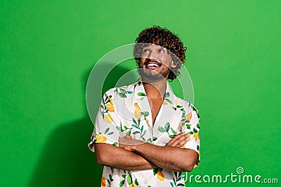 Photo of confident dreamy latin guy dressed print shirt arms crossed looking empty space isolated green color background Stock Photo