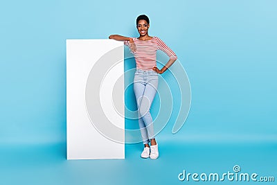 Photo of confident positive advertiser lady lean white placard empty space wear striped shirt isolated blue color Stock Photo