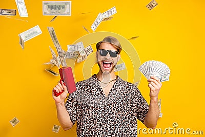Photo of cool handsome young gentleman dressed print shirt dark glasses shooting money gun isolated yellow color Stock Photo