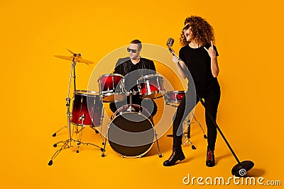 Photo of cool rock group handsome guy playing drum instruments crazy girl sing retro old fashion mic concert show horns Stock Photo