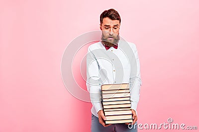 Photo of crying frustrated guy holding heavy stack of books in hands pastel background Stock Photo
