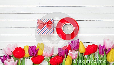 Photo of cup of coffee, cute gift and colorful tulips Stock Photo