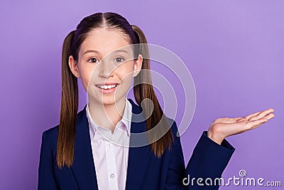 Photo of cute charming school girl wear blue uniform holding arm empty space smiling isolated purple color background Stock Photo