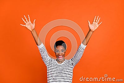 Photo of cute impressed butch lady dressed sweater rising arms smiling isolated orange color background Stock Photo