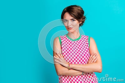 Photo of cute lovely girl wear stylish clothes standing with folded arms presenting empty space banner isolated on cyan Stock Photo