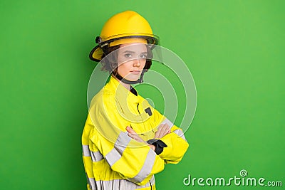 Photo of cute serious young firewoman dressed yellow uniform helmet arms crossed empty space isolated green color Stock Photo