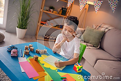 Photo of cute sweet boy sit desktop writing letters on art craft lesson in comfort cozy domestic playroom Stock Photo