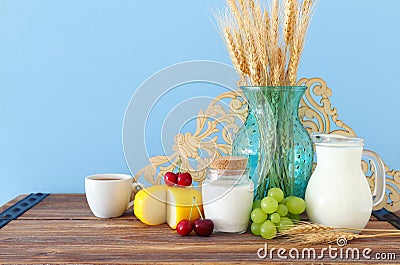Photo of dairy products over old wooden table and pastel background. Symbols of jewish holiday - Shavuot Stock Photo