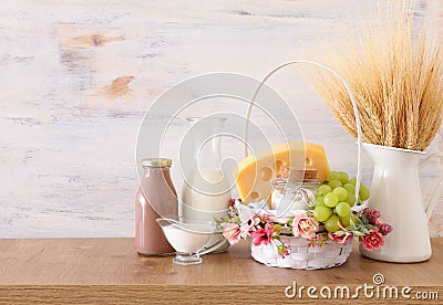 Photo of dairy products over wooden table. Symbols of jewish holiday - Shavuot Stock Photo