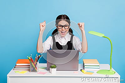 Photo delighted high school girl sit table study remote use laptop celebrate good grades test raise fists scream wear Stock Photo