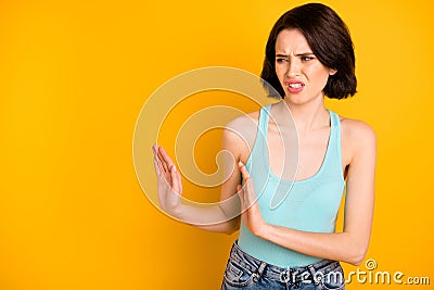 Photo of depressed scared disgusted girl showing someone to get away from her while isolated with yellow background Stock Photo