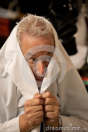 Photo of a doctor hiding under his lab coat Stock Photo