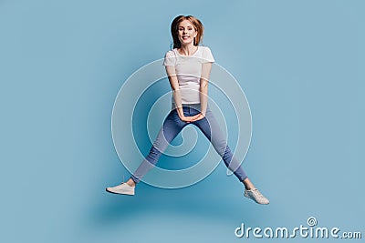 Photo of dreamy adorable blonde cute lady hold hands jump have fun wear casual clothes on blue color background Stock Photo