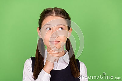 Photo of dreamy charming school girl dressed formal clothes arm chin looking empty space green color background Stock Photo