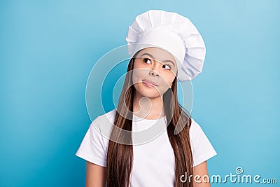 Photo of dreamy happy little girl cook look empty space lick lips imagine good meal isolated on blue color background Stock Photo