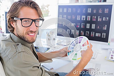 Photo editor looking at colour wheel and turning to smile Stock Photo