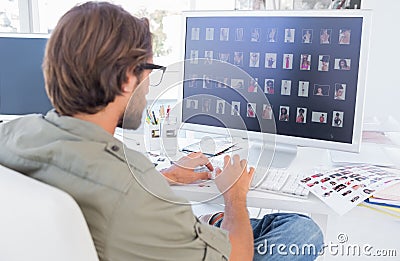 Photo editor looking at thumbnails on computer Stock Photo