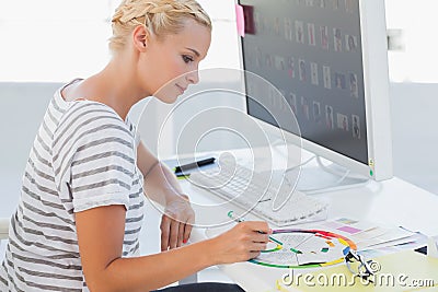 Photo editor pointing at a colour wheel Stock Photo