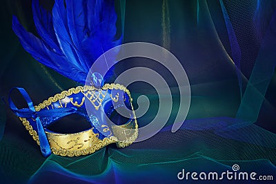 Photo of elegant and delicate Venetian mask over blue dark chiffon background Stock Photo