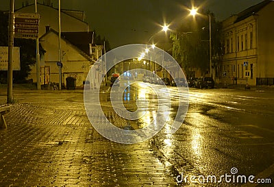 Empty wet street at night illuminated by lamps Stock Photo