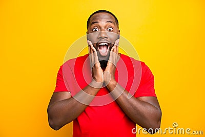 Photo of excited ecstatic rejoicing overjoyed black man admiring something adoring while isolated with yellow background Stock Photo