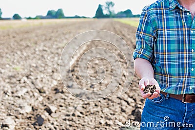 Farmer showing soil in farm Stock Photo