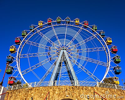Ferris wheel with colorful swings at sunsets with blue sky in front view Stock Photo