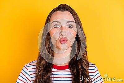 Photo of flirty adorable young lady dressed striped t-shirt sending you kiss isolated yellow color background Stock Photo