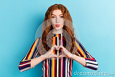 Photo of flirty orange hairdo millennial lady show heart blow kiss wear colorful shirt on blue color background Stock Photo