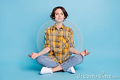 Photo of focused concentrated lady sit floor meditate close eyes wear checkered shirt isolated blue color background Stock Photo