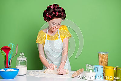 Photo of focused girl knead fresh pie cake dough table prepare home made dish wear yellow dotted t-shirt hair rollers Stock Photo