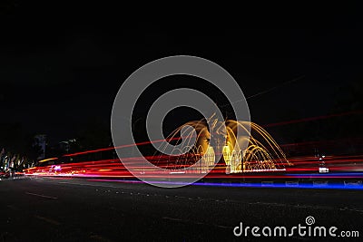 photo light trail blue and yellow lamp fountain and fish statue city Stock Photo