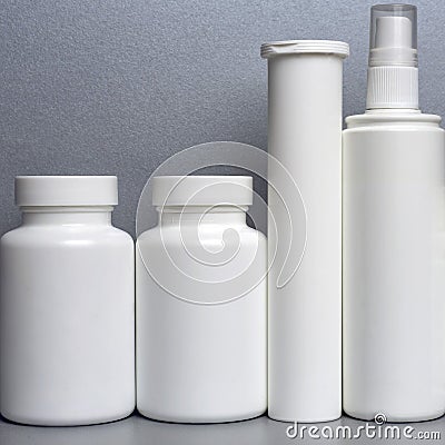 Photo of four plastic cans for package pills and vitamins and antiseptic spray for protection against coronavirus KOVID-19 on a gr Stock Photo
