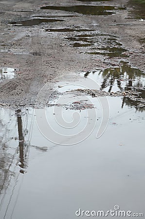 Photo of a fragment of a destroyed road with large puddles in rainy weather Stock Photo