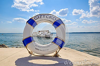 Photo frame (Lifebuoy) with a cruise ship sailing on Lake Niegocin, Gizycko, Masuria, Poland. Editorial Stock Photo