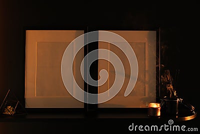 Two empty photo frames on a shelf on a dark background. mocap. modern interior in dark colors. close-up of candle and photo frame Stock Photo