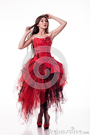 Beautiful girl in red dress posing on camera on white background. Stock Photo
