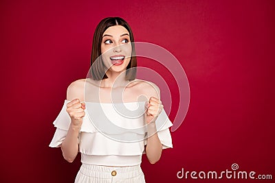 Photo of funky brown hairdo young lady hands fists look empty space wear white bare shoulders top isolated on red color Stock Photo