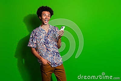 Photo of funky excited man dressed print shirt chatting instagram twitter telegram facebook empty space isolated green Stock Photo