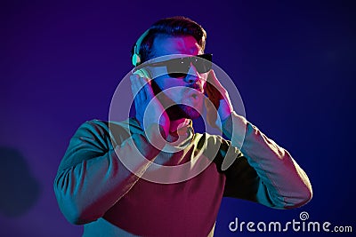 Photo of funky funny young man wear headphones sunglass clubber night life isolated on neon background Stock Photo
