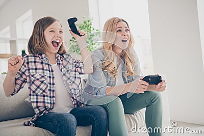 Photo of funny blond lady mom daughter sitting comfy couch joystick play video game winner loser stay home quarantine Stock Photo