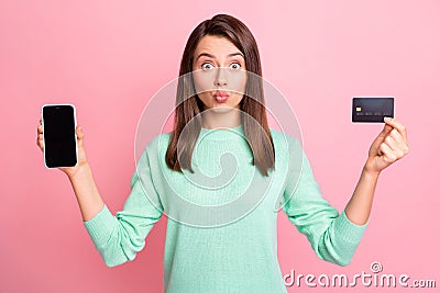 Photo of girl hold phone screen empty space debit card send air kiss wear teal pullover isolated pink color background Stock Photo